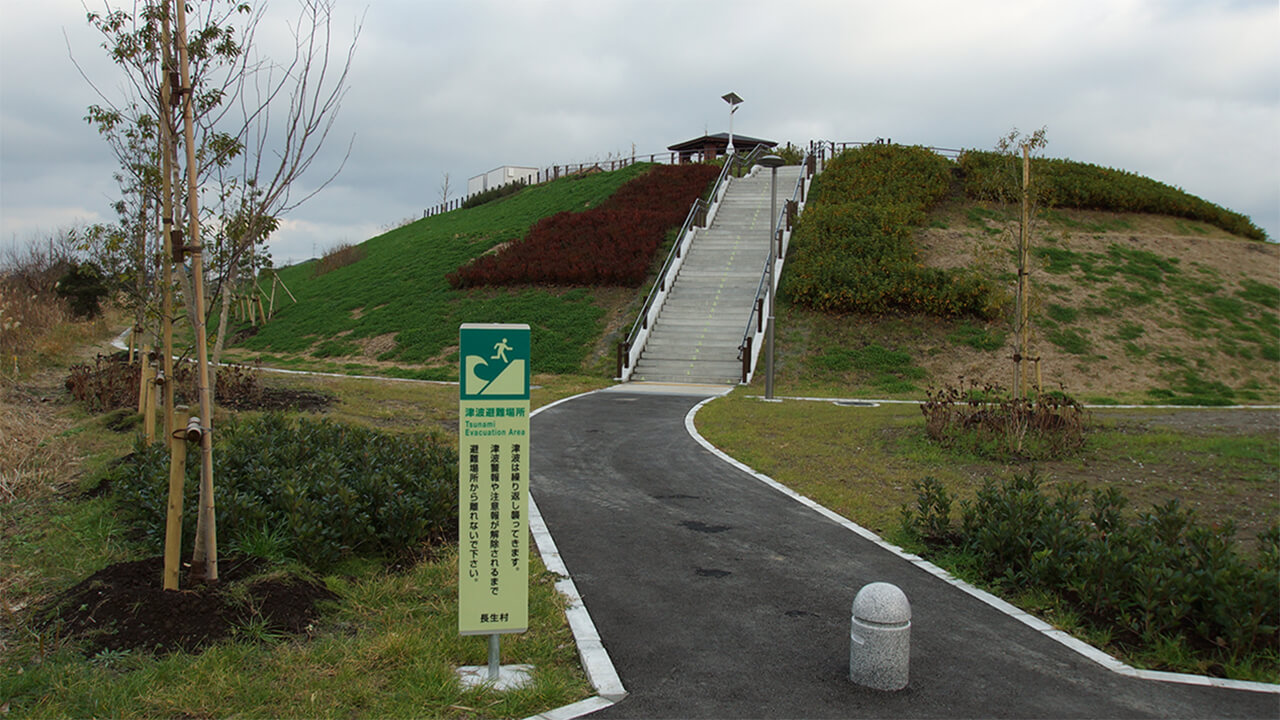 千葉県長生村の築山公園型津波避難場所に避難場所であることを標示する明視下のハイブリッドストーン アベイラス アルシオール サインプレート（高輝度蓄光式屋外用案内標示板）