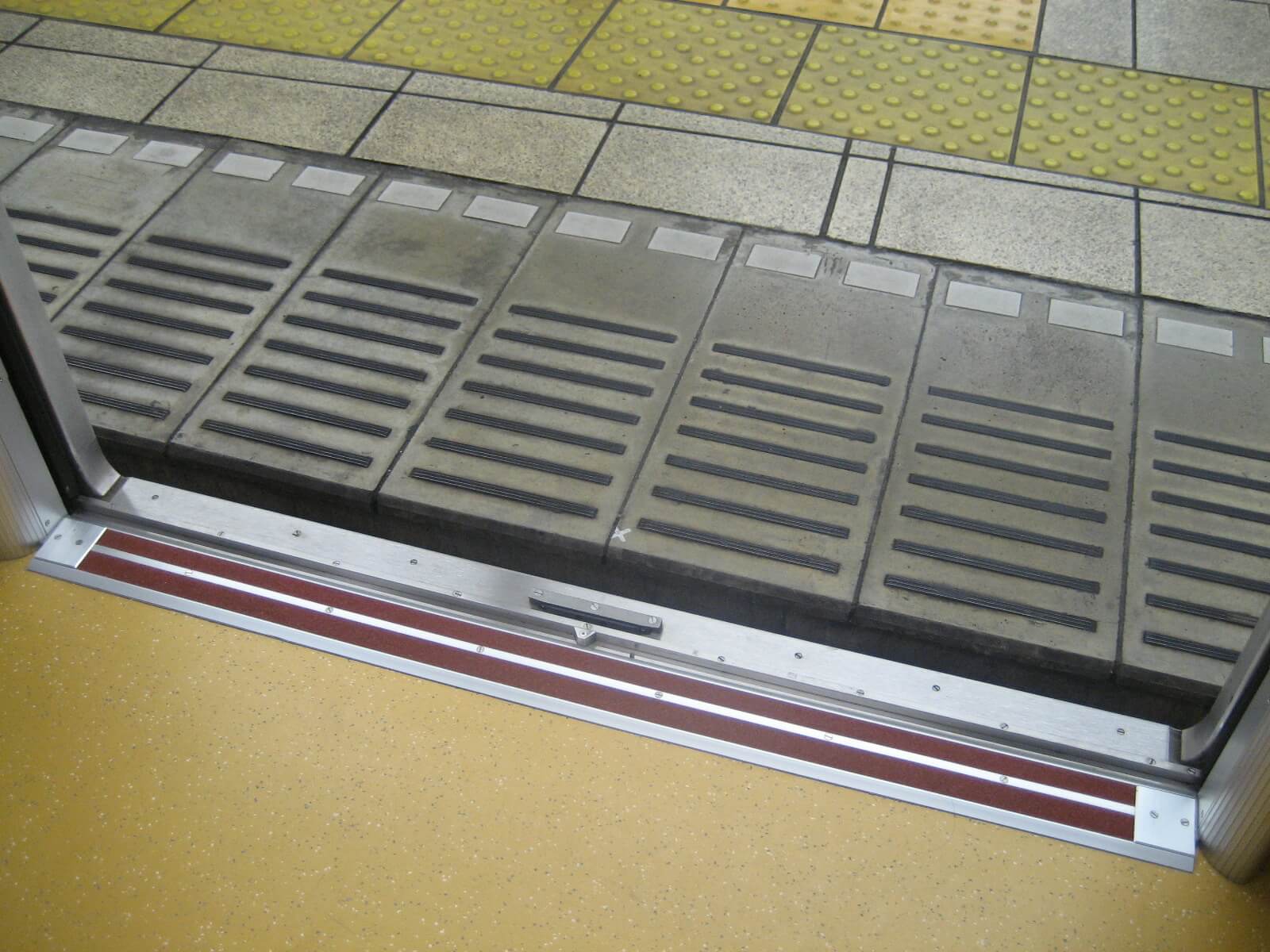 東京メトロ地下鉄車両の見切材として各車両ドアの床面に設置されたハイブリッドストーン アベイラス アンプロップをドアが開いた状態で車両内から見た様子