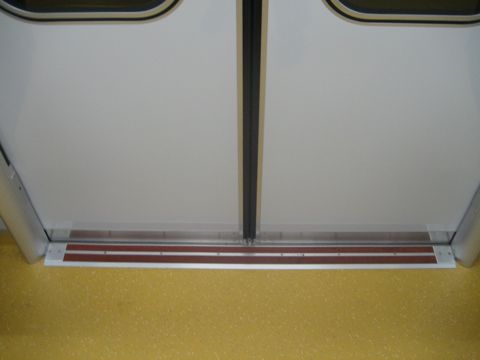 東京メトロ地下鉄車両の見切材として各車両ドアの床面に設置されたハイブリッドストーン アベイラス アンプロップをドアが閉まった状態で車両内から見た拡大図