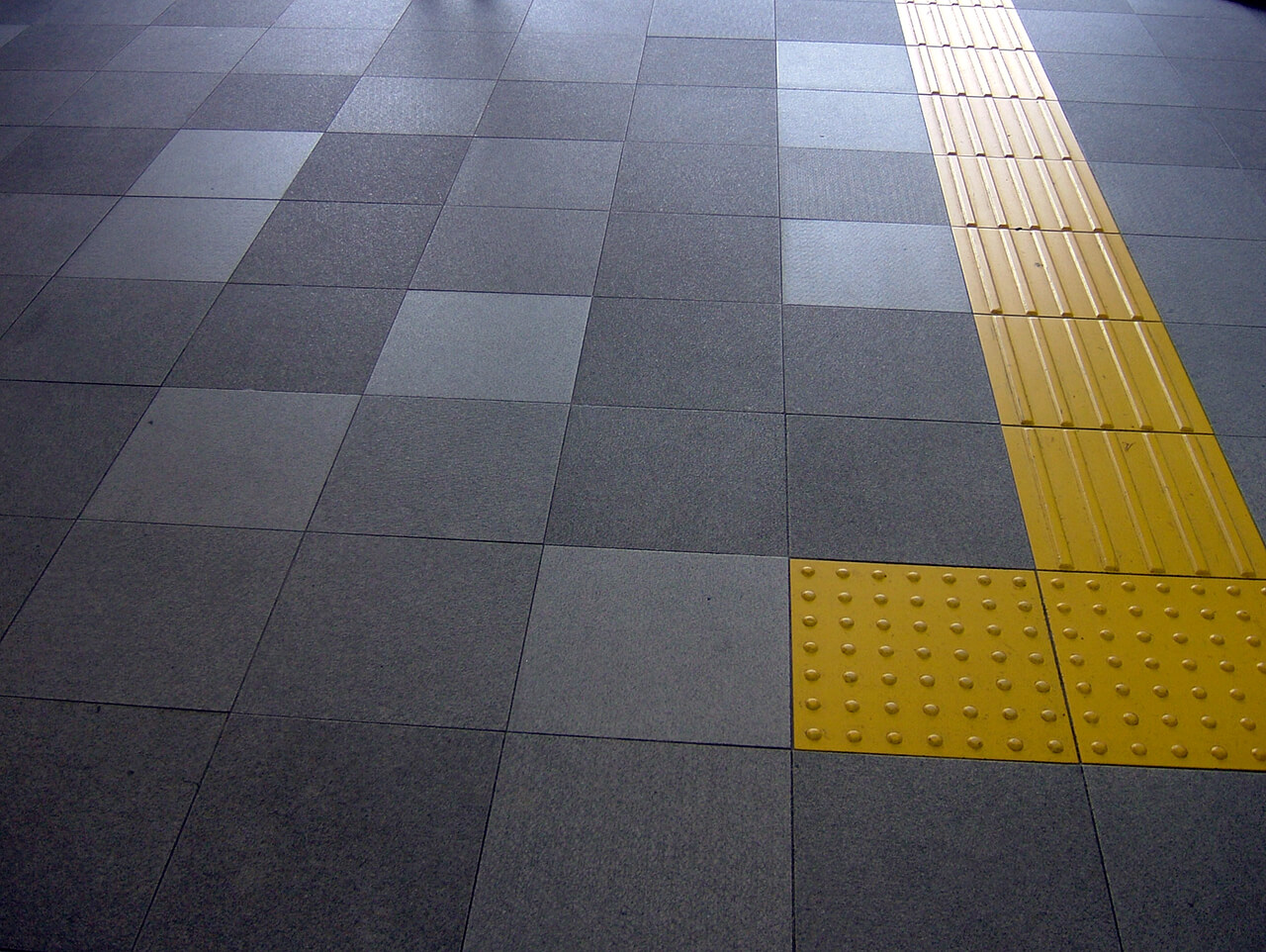 屋外からJR東日本新宿駅東口へ繋がる階段手前の床に使用されているハイブリッドストーン アベイラス アンプロップの拡大図