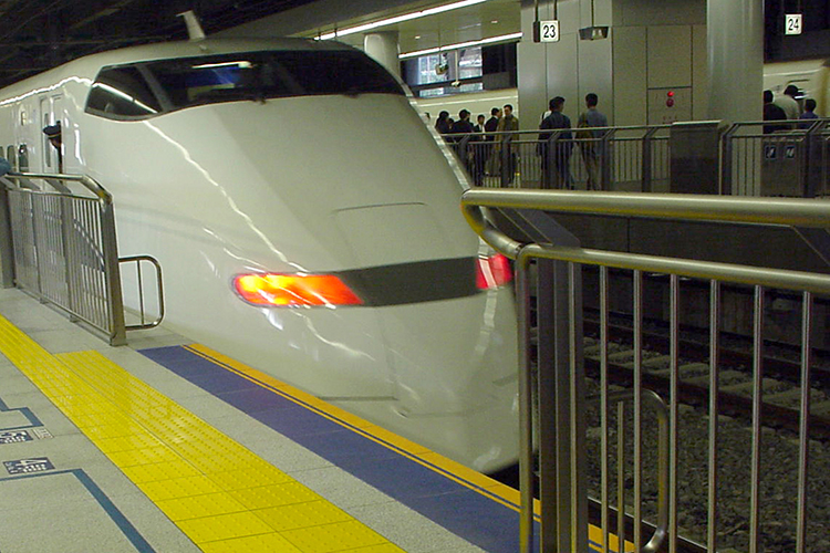 東海道新幹線品川駅のホーム笠石として使用されているハイブリッドストーン アベイラス アンプロップの横を新幹線300系が走る様子