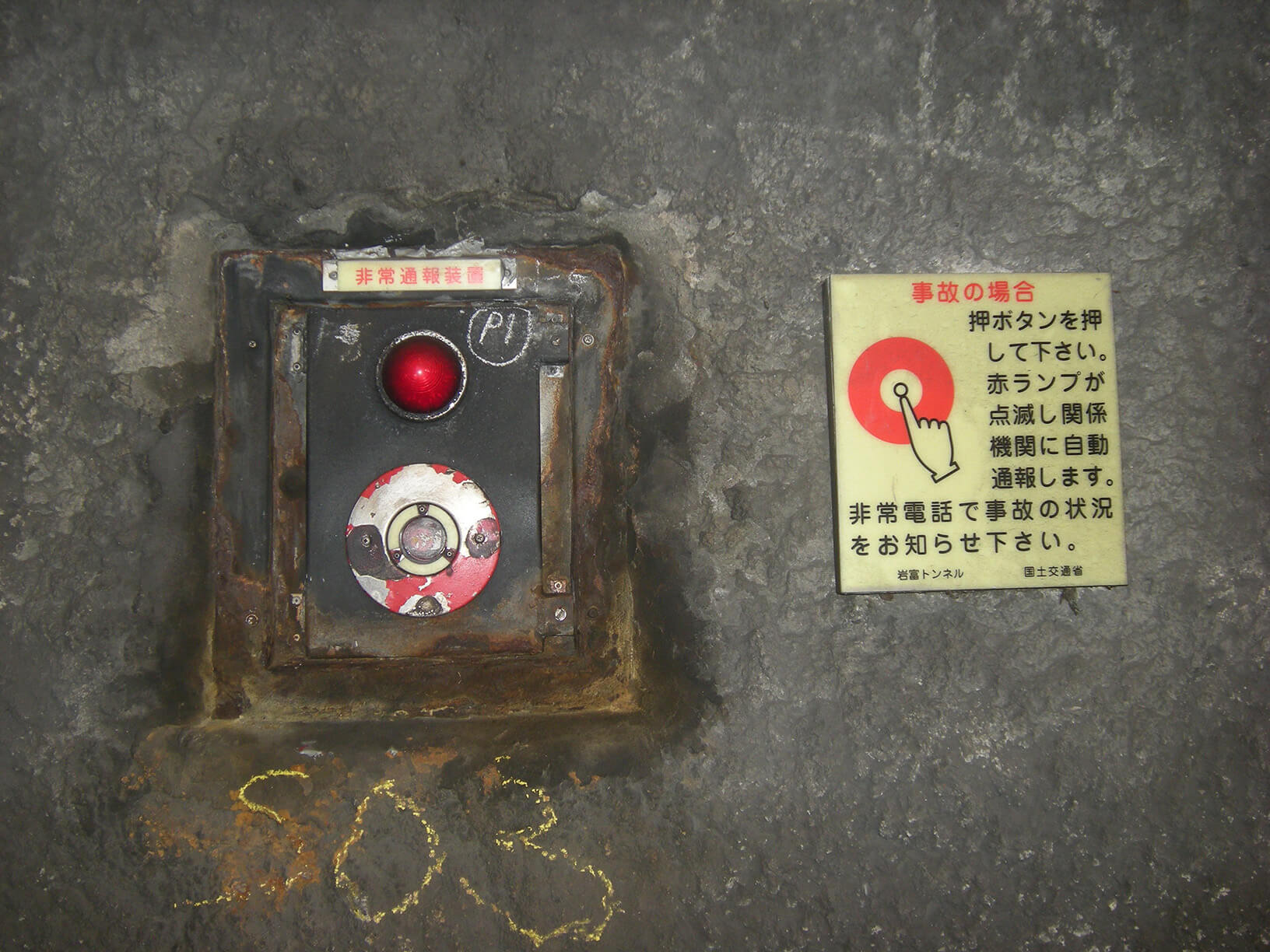 千葉県岩富トンネルに施工された非常通報装置の使用方法を示す明視下のハイブリッドストーン アベイラス アルシオール サインプレート（高輝度蓄光式屋外用案内標示板）