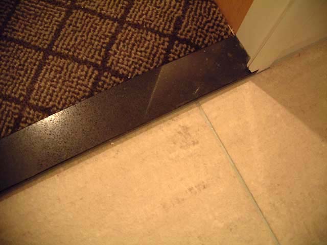 丸の内ホテルの客室内のバスルーム入口に施工されたハイブリッドストーン アベイラス ポリッシュのくつずり