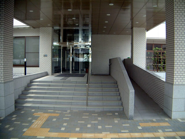 介護施設のエントランス前の階段とスロープに施工されたハイブリッドストーン アベイラス アンプロップの全体図