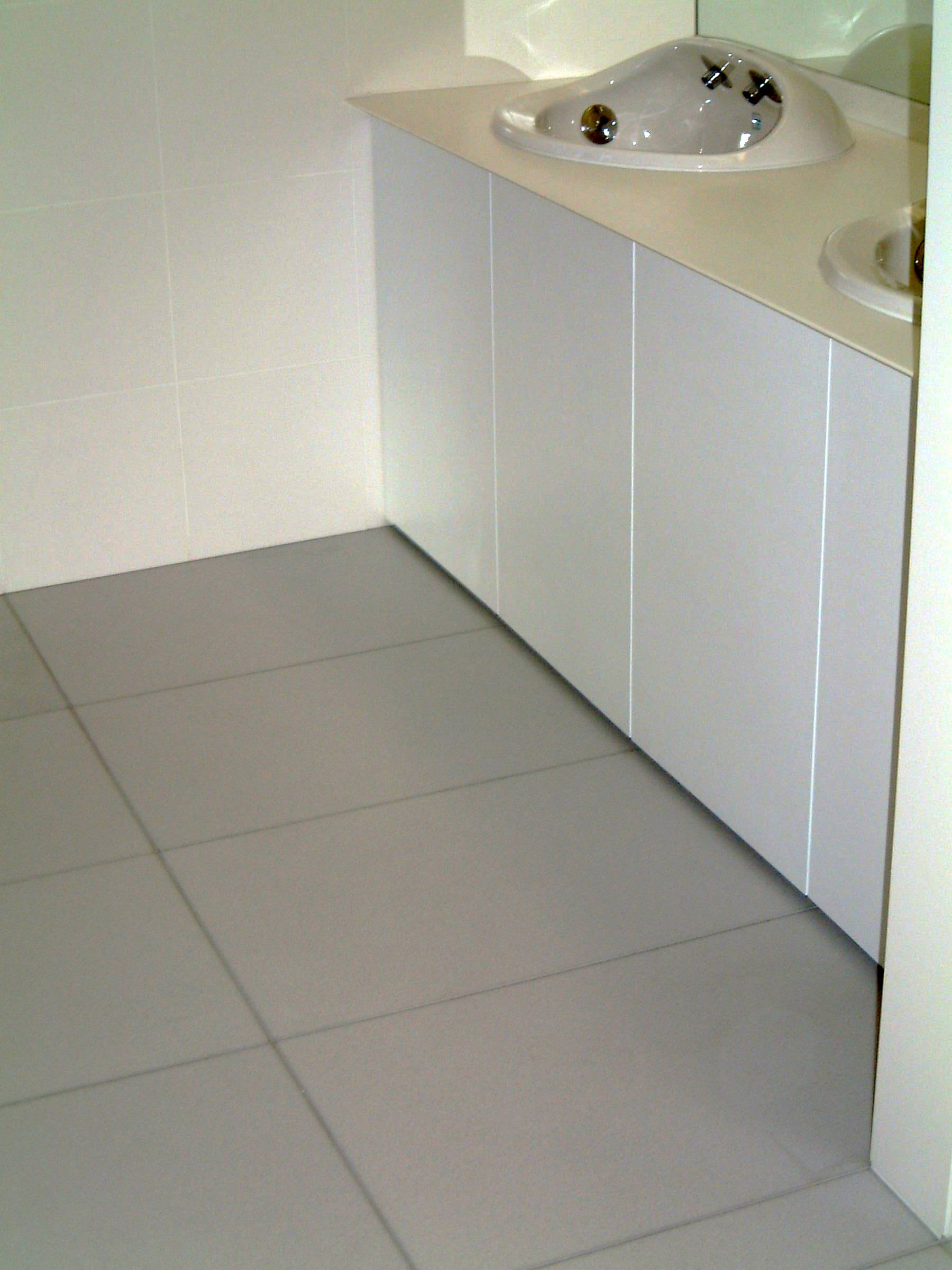 流し台周りのトイレ床に使用されているハイブリッドストーン アベイラス ポリッシュ ホワイト色