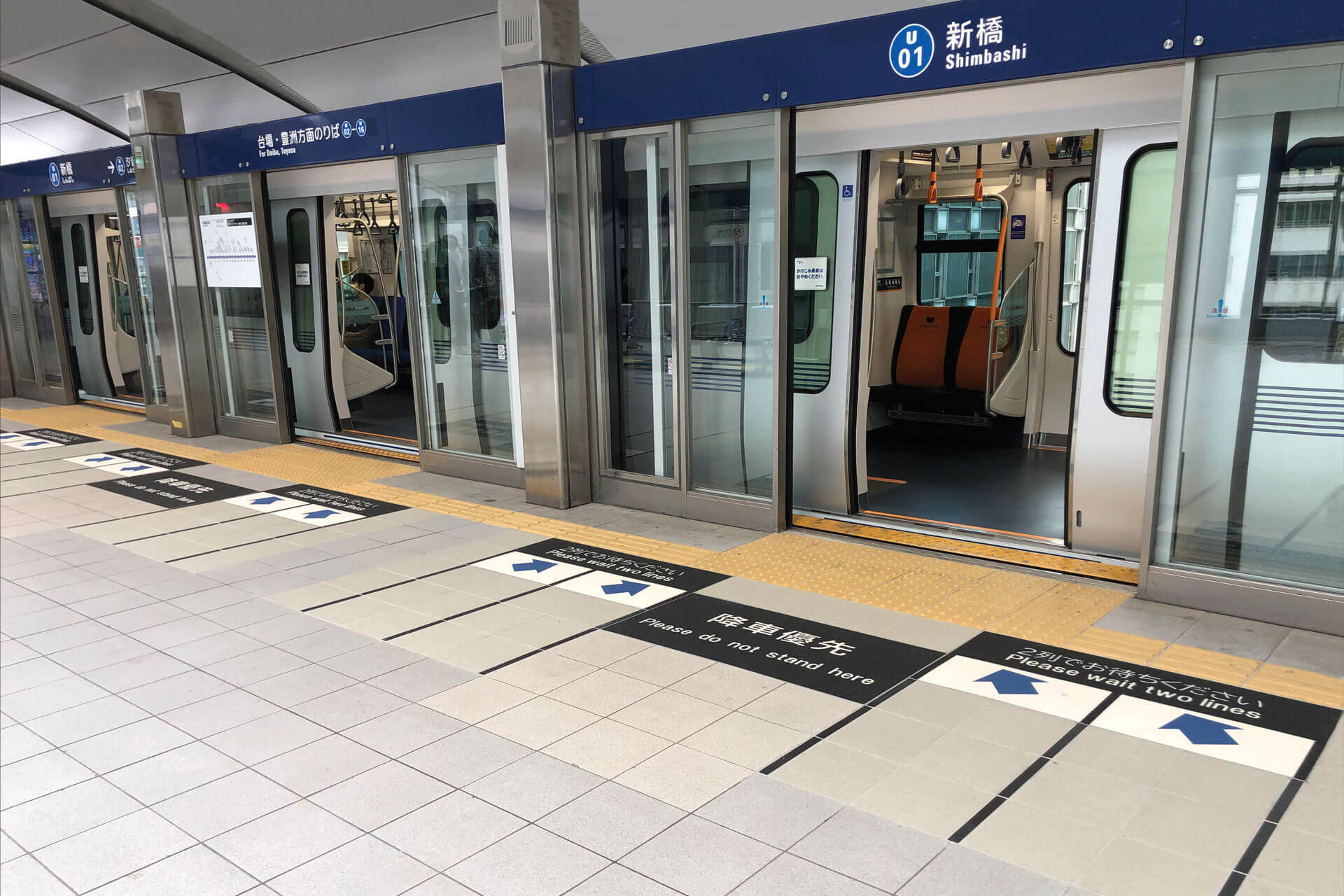 新橋駅に止まっている車両とホームに施工されたハイブリッドストーン アベイラス アンプロップを斜めから見た様子