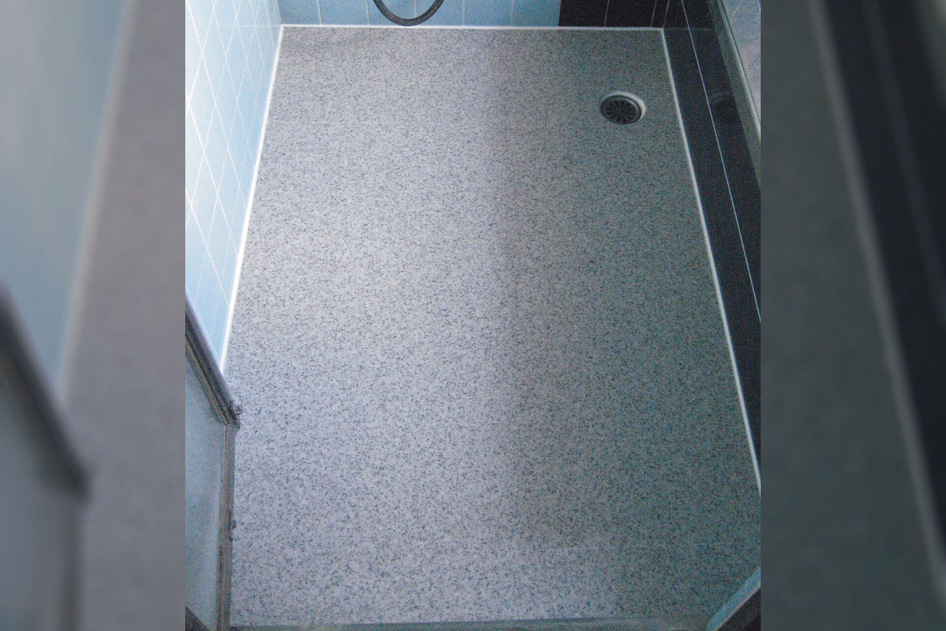 タイル床をハイブリッドストーン アベイラス スーパー浴室床材ダークグレー色で改修した様子