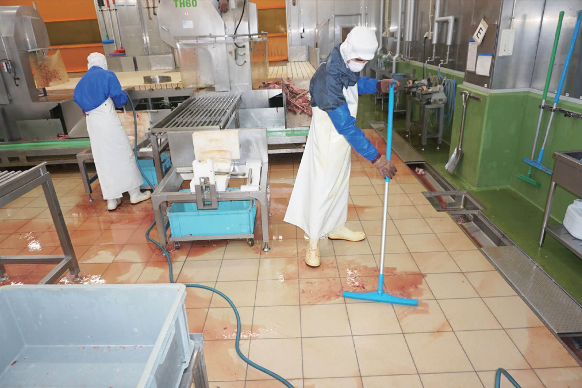 HACCP対応防滑床材であるハイブリッドストーン アベイラス アンプロップをゴムワイパーで清掃中