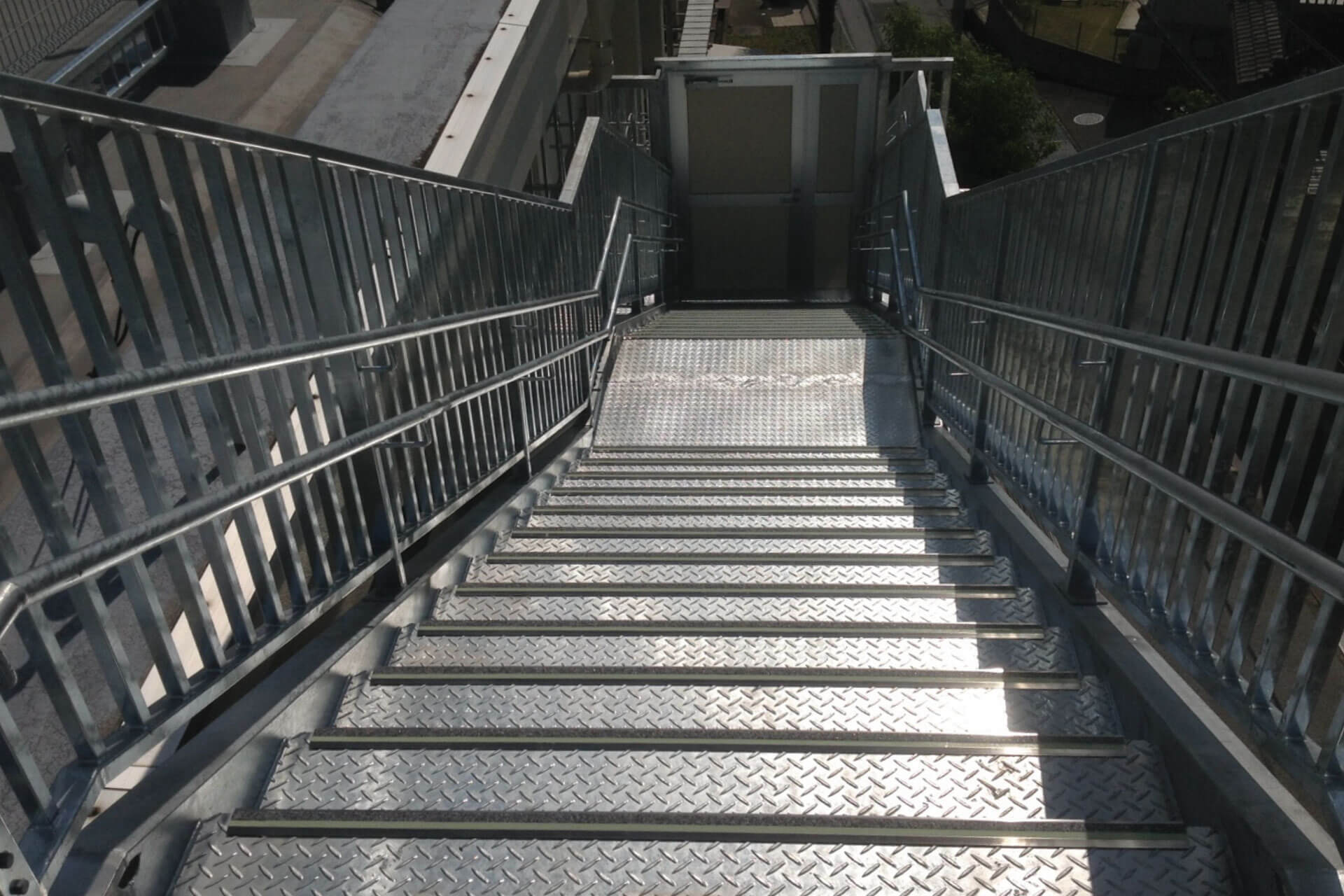 高知市立大津小学校に施工された明視下のハイブリッドストーン アベイラス ステップ（高輝度蓄光式防滑階段材）を階段上から見た角度