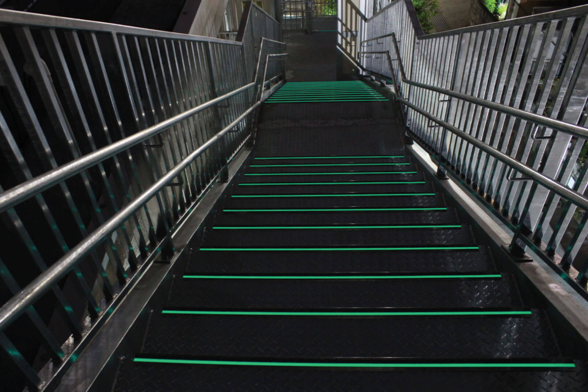 高知市立大津小学校に施工された暗視下のハイブリッドストーン アベイラス ステップ（高輝度蓄光式防滑階段材）を階段上から見た角度