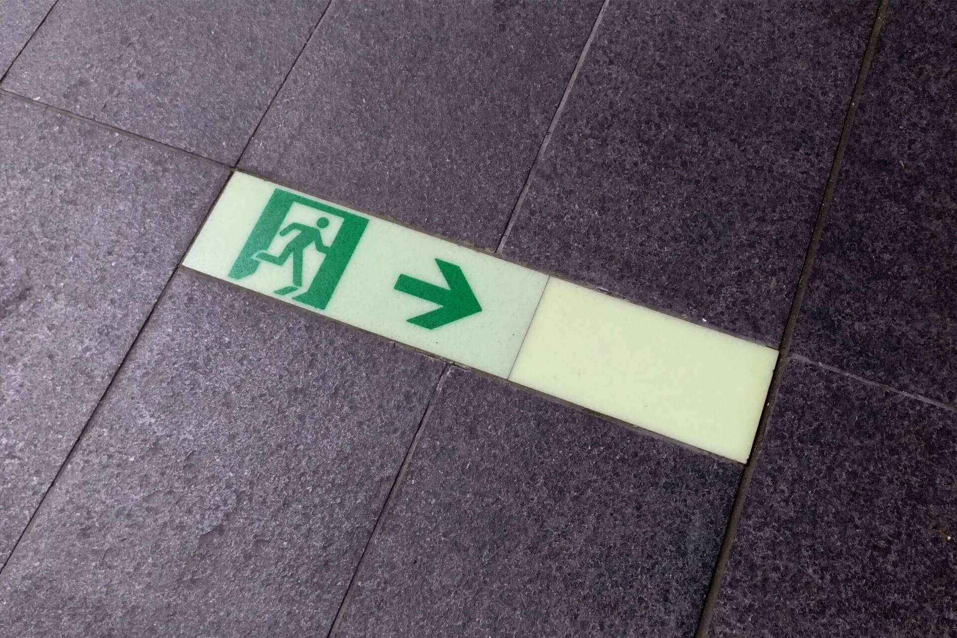東京大学2号館の床に施工されたハイブリッドストーン アベイラス アルシオール高輝度蓄光式誘導標識（消防避難設備認定品）拡大